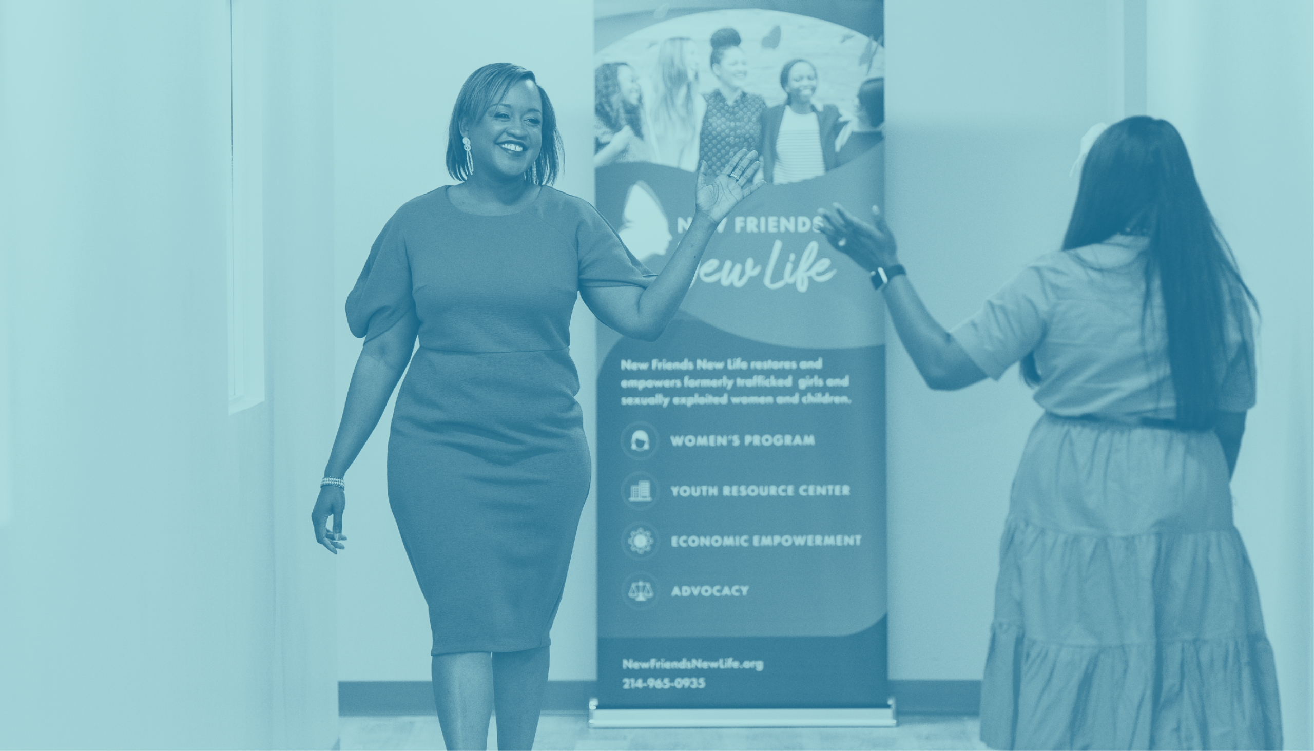 Two women about to high-five in a hallway