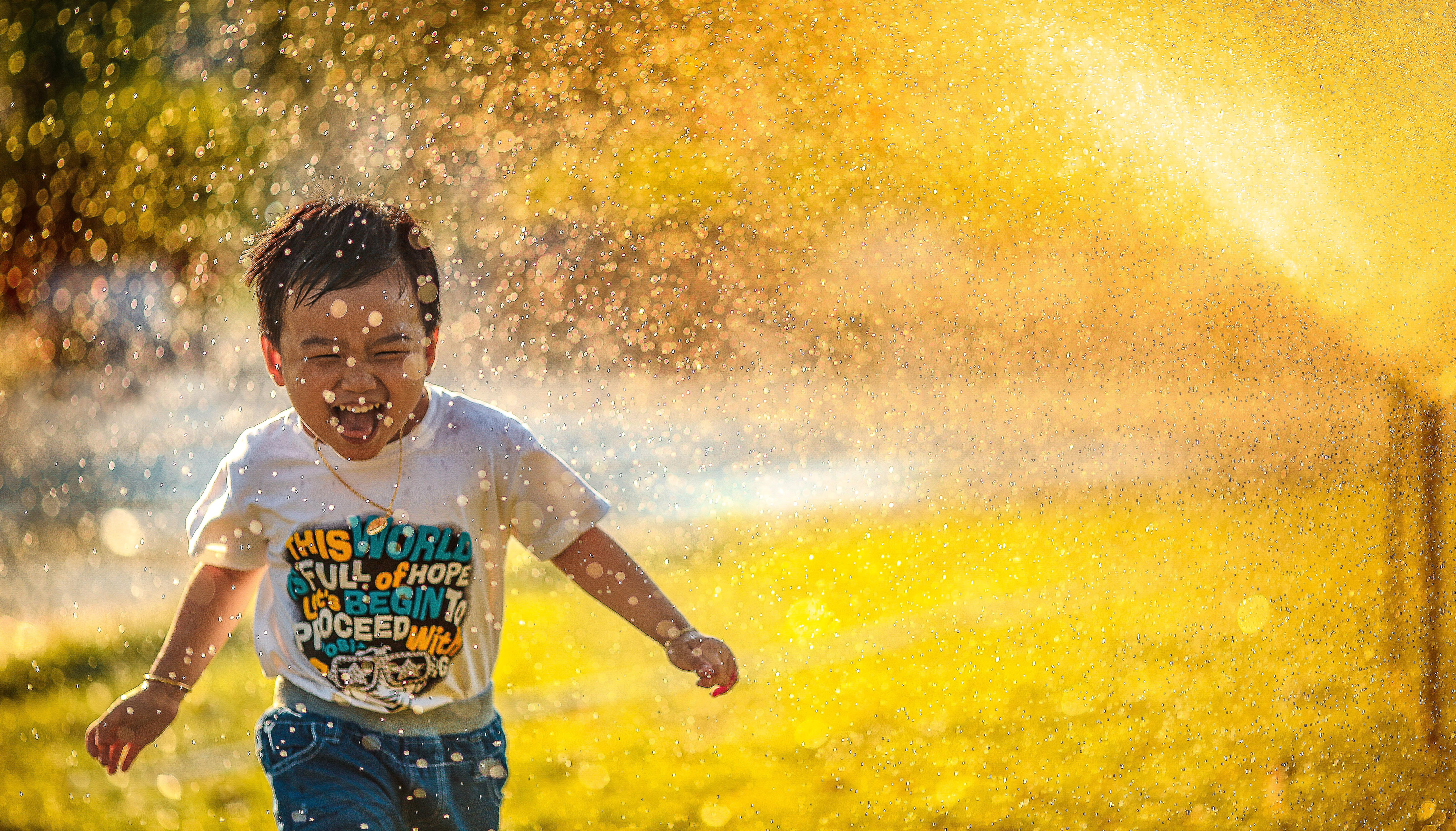 Child playing in the sprinkler outside