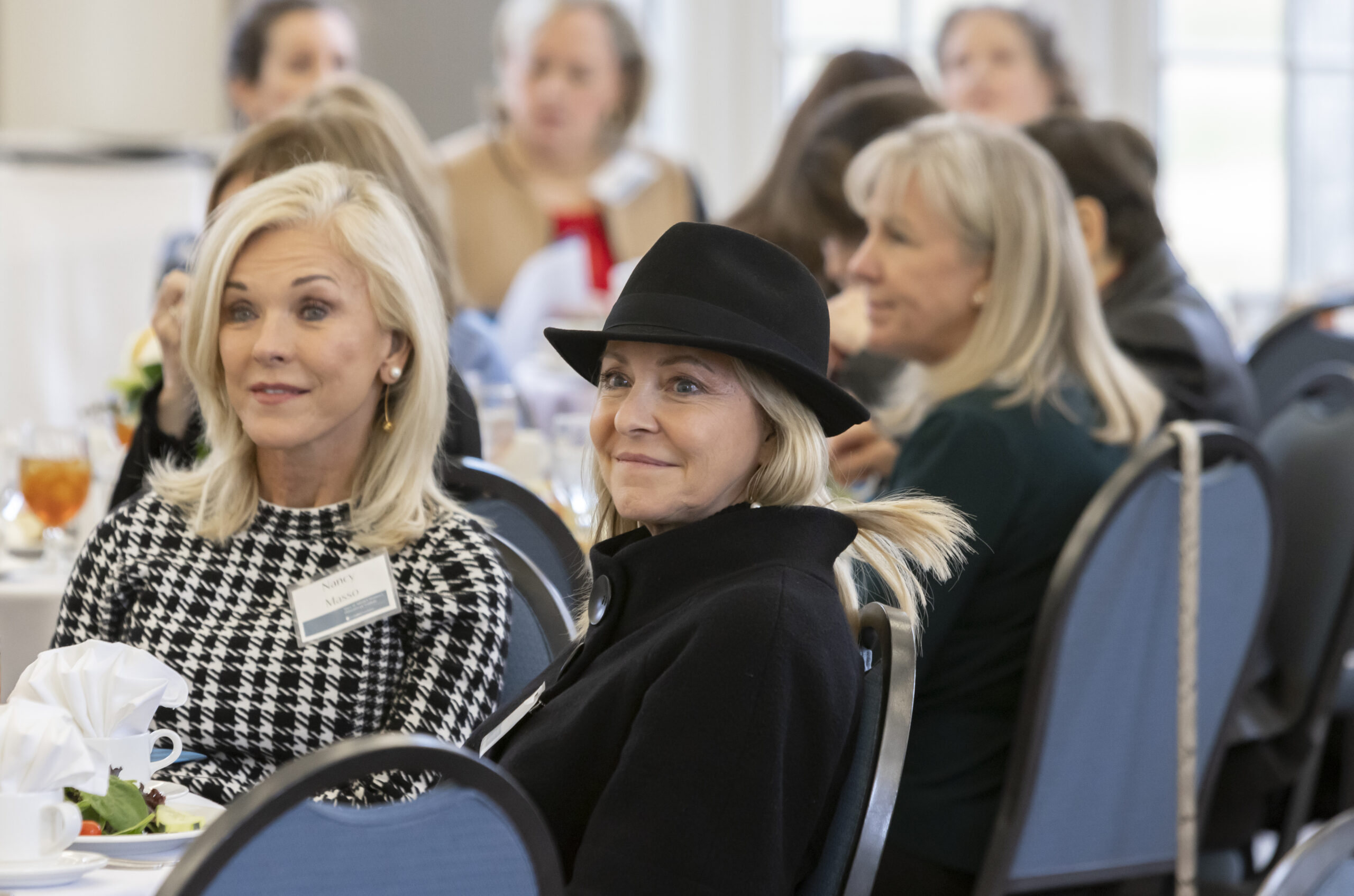 Women sitting at tables and listening to speaker